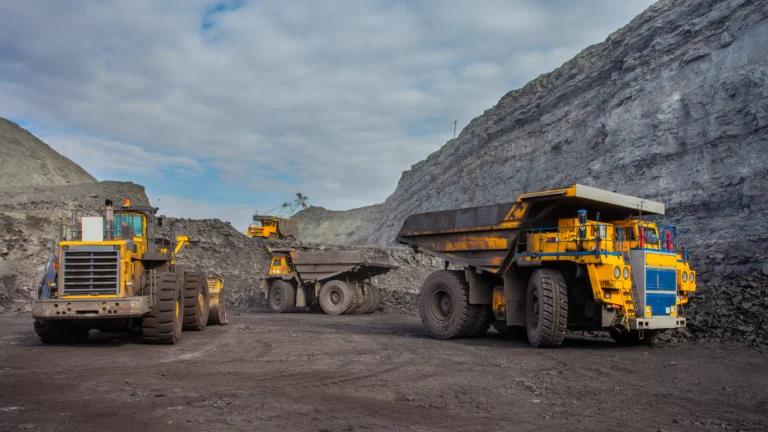 Operação de mineração no Brasil com caminhões fora de estrada e equipamentos em área de lavra.