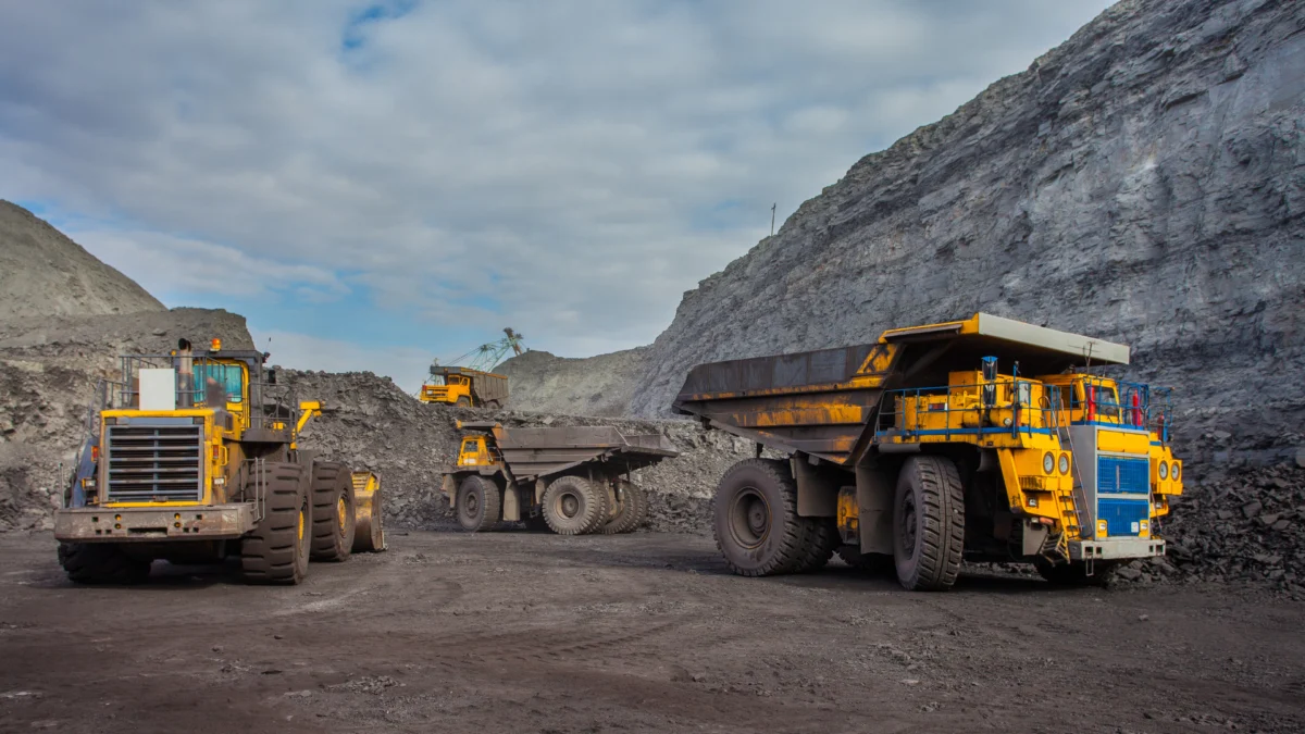 Operação de mineração no Brasil com caminhões fora de estrada e equipamentos em área de lavra.