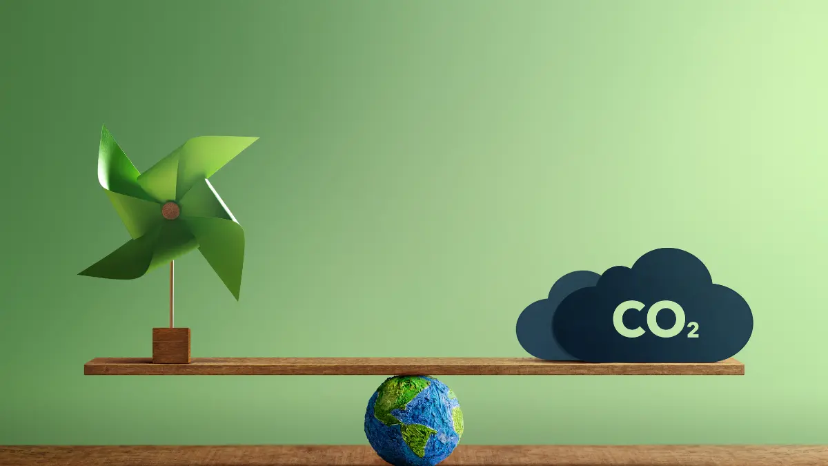 Uma gangorra equilibrada sobre um globo terrestre de papel machê, representando o mercado de créditos de carbono. Do lado esquerdo, um cata-vento verde simboliza energias renováveis. Do lado direito, uma nuvem azul escura de emissões de CO2 contém o texto 'VALORIZAÇÃO DE ATIVOS' e 'GERAÇÃO DE RECEITA', ilustrando a monetização da descarbonização empresarial.